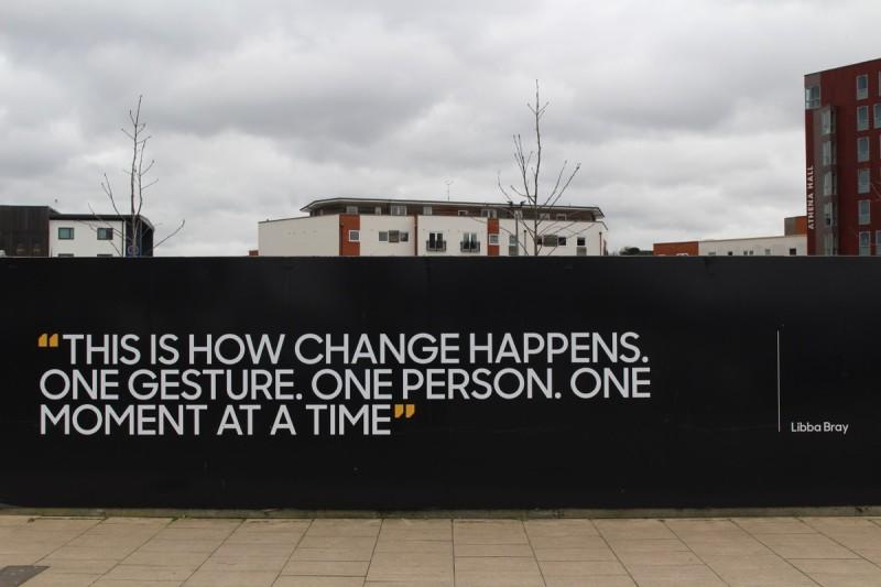 Muro en la calle con la frase de Libba Bray: Así es como sucede el cambio. Un gesto. Una persona, un momento cada vez.